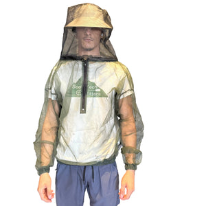 A man wearing a Bushline Outdoors Mesh Adult Pullover Bug Jackets with Zippered Chest, Hood & Neck light in green and beige mosquito net hooded shirt, paired with blue shorts, shown against a plain white background.
 | ScoutTech Outfitters Mississauga Store