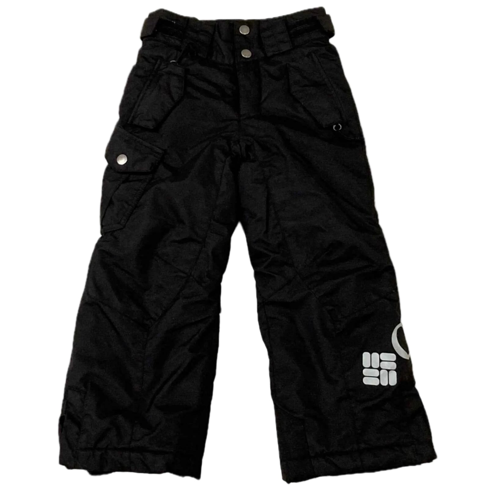 Columbia Boy's Bugaboo Waterproof Insulated Snow Pants in black lying flat on a white background.  View of the front side. A large Columbia label written across the left leg.  Two front pockets with zippers and flaps are shown.  A cargo pocket on the right leg and front fly are secured by 2 silver snaps.  There is also an adjustable waist band with hook and loop closures and belt loops. | ScoutTech Outfitters Mississauga Store
