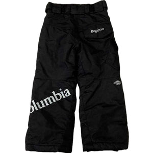 Columbia Boy's Bugaboo Waterproof Insulated Snow Pants in black view of back side lying flat on a white background.  Visible details are a back pocket flap with Bugaboo spelled out,  a large Columbia label written across the left leg and a reflective omni-tech diamond shaped logo on the right leg all in white.  There is also an adjustable waist band with hook and loop closures and belt loops. | ScoutTech Outfitters Mississauga Store