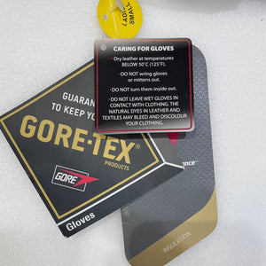 Gore-Tex gloves packaging and care card on white foam background. The package is black with gold lettering and a red Gore logo, with a yellow circular label reading LAB SAFE. | ScoutTech Outfitters
