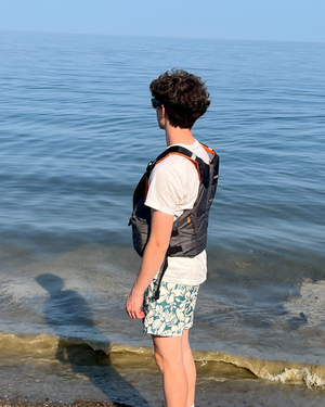 NRS Men's Oso PFD's Front Zip Life Jackets in Grey with Orange Accents On Model Side View | ScoutTech Outfitters Mississauga Store