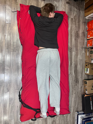 Outdoor Survival Canada Igloo -60C Down Multi-Season Sleeping Bag Red with person lying on it | ScoutTech Mississauga