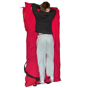 Outdoor Survival Canada Igloo -70C Multi-Season Down Sleeping Bag in Red with 6 foot 6 inch tall Male Model relaxing on it | ScoutTech Mississauga