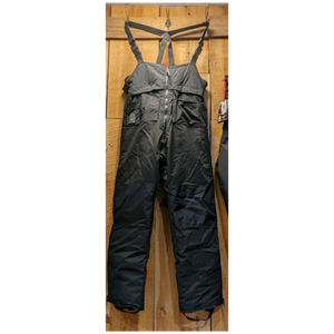Outdoor Survival Canada OSC Unisex Klin Down Bib Pants in Black Front View of Snow Pants Hanging on a Wooden Wall | ScoutTech Outfitters Mississauga Store