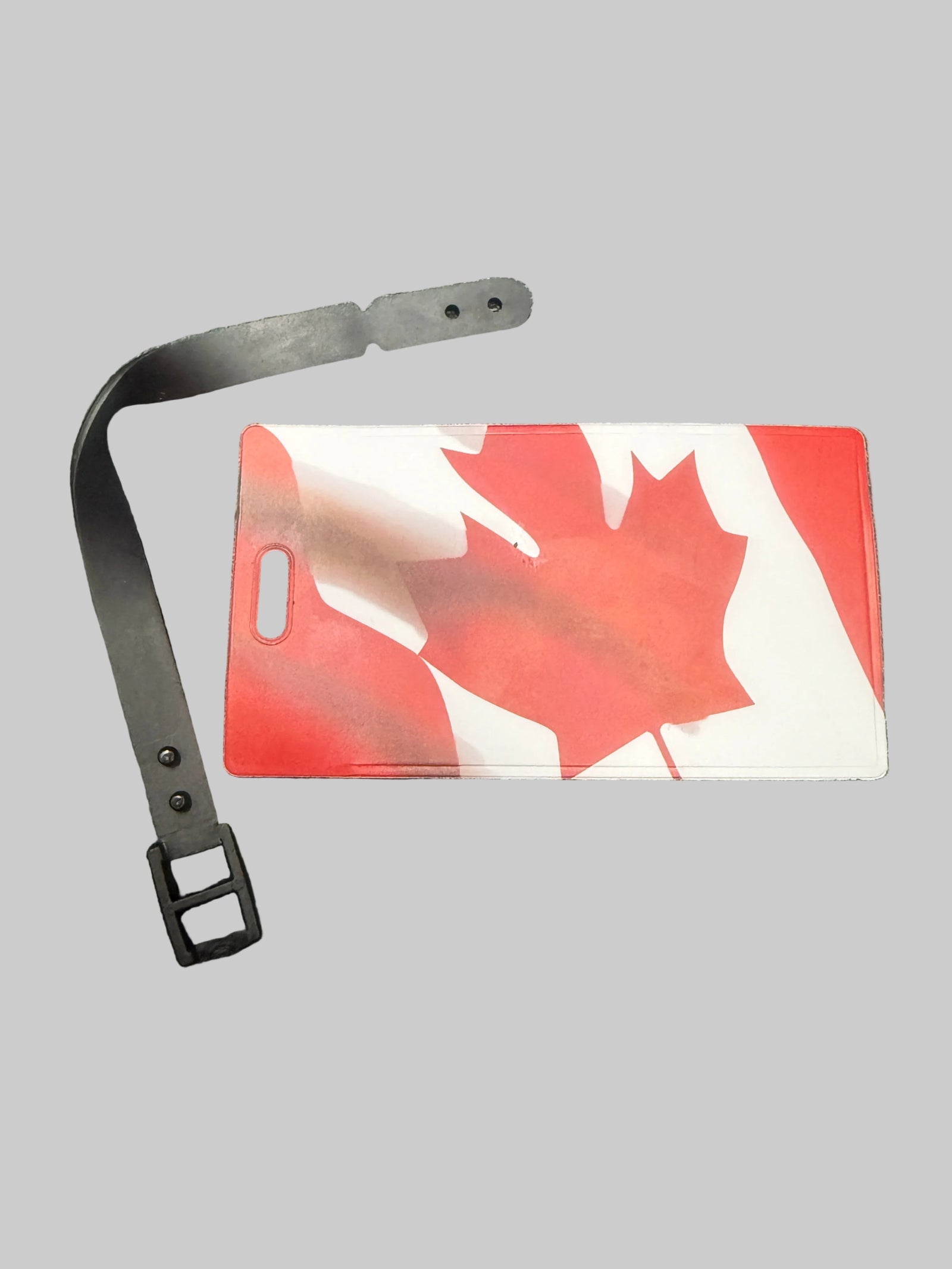 Red and white card with a maple leaf design on a black surface