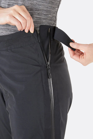 Rab Women's Kangri GTX Rain Pants in Black with Close-Up of Waist and Upper Zip Closure | ScoutTech Outfitters 