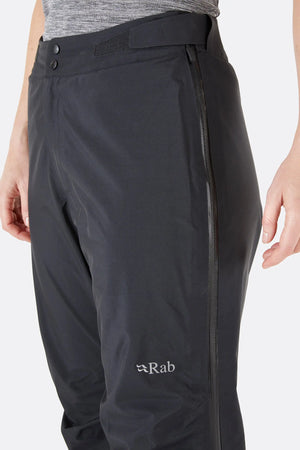 Rab Women's Kangri GTX Rain Pants in Black with Close up View of Adjustable Waist and Left Side Zip with RAB Logo | ScoutTech